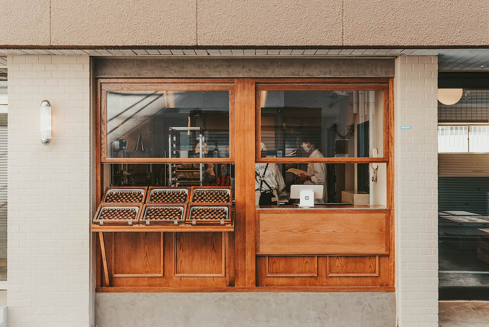 「KURAMAE CANNELE」は2023年1月に東京・蔵前にオープンした焼き立てカヌレの専門店。併設工房で焼き上げた焼き立てのカヌレ「クラマエ・カヌレ」を販売するテイクアウトカウンターと、同店でしか味わえない”カヌレ専用卵”を使用したプレミアムカヌレ「グランカヌレ」のスイーツプレートを提供するカフェ「KURAMAE CANNELE CAFE」を展開している。