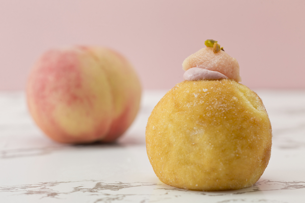 生ドーナツ専門店「PIECE OF BAKE」は8月1日より、期間限定で「桃の生ドーナツ」および「マンゴーの生ドーナツ」を展開する。価格はそれぞれ税込み518円。