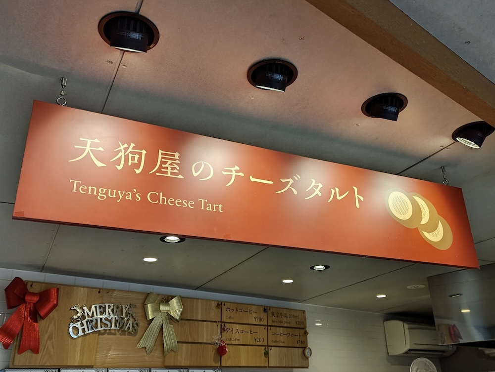 The 'Takaosan Cheese Tart' sales area is unmistakable due to its large signboard.