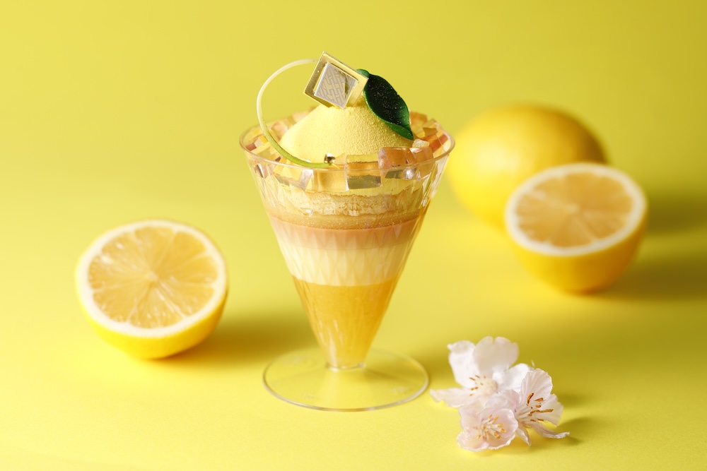 資生堂パーラーは4月1日〜4月30日、銀座本店ショップにて、「瀬戸内レモンのパフェケーキ さくらのアクセント」を提供する。価格は税込み1,188円。