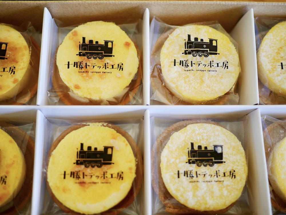 看板商品「ナチュラルチーズケーキ アソートボックス」左：北海道フロマージュ、→：カマンベールフロマージュ