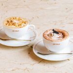 左から「キャラメルヘーゼルナッツラテ」税込み950円、「ホットチョコレート」税込み950円(各ドリンクは青山店、渋谷店、京都新風館店、大阪店、福岡店で展開)