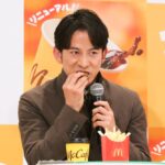 赤木裕さんから手渡された「クリームブリュレホットドーナツ」を試食する岡田准一さん