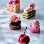 奥から「桜ストロベリーショートケーキ」税込み1,200円、「抹茶と桜のオペラケーキ」税込み1,200円、「70%ダークチョコレートと桜のタルト」税込み1,600円、「マカダミアナッツと桜のパリブレストシュー」税込み1,250円、「チェリーと桜のケーキ」税込み1,300円