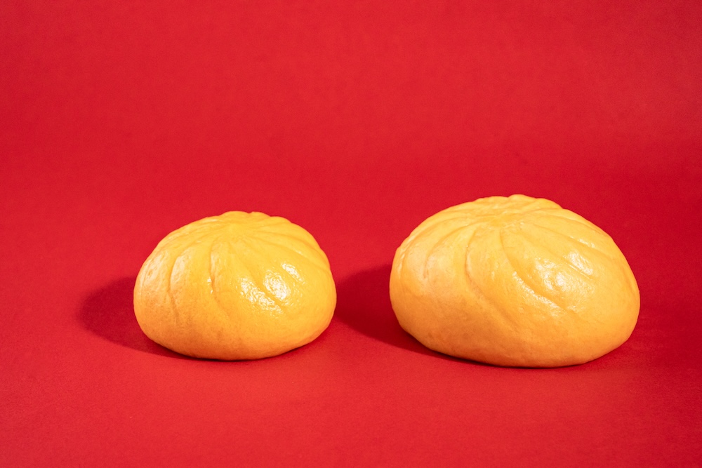 3月24日より発売される「のびーるチーズのコク旨ピザまん」税込み170円（右が増量品）