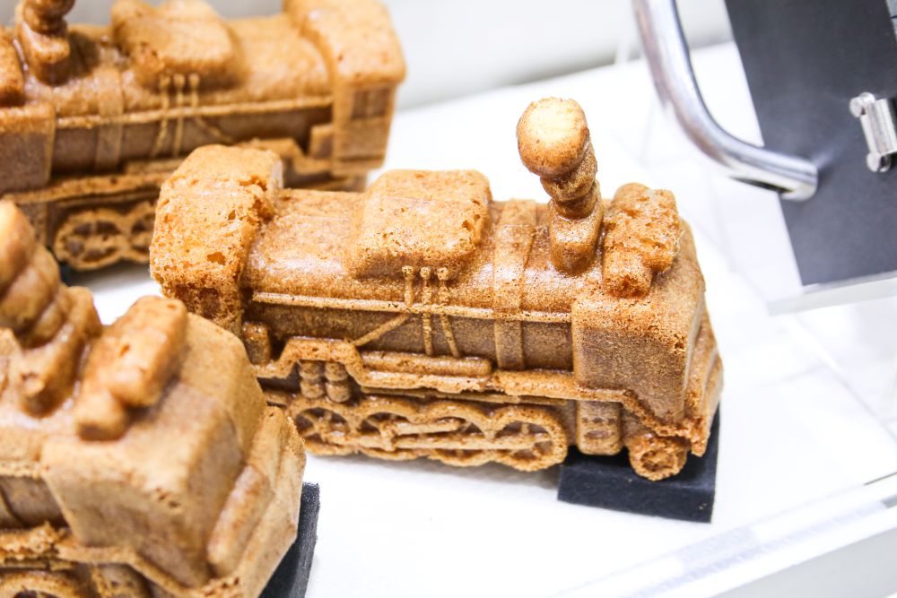 「小松鋳型製作所」の焼き型と「株式会社オーバン」のミックス粉で作られた展示用人形焼きのイメージ