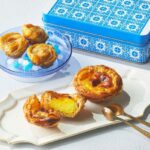 5月3日のみ販売される「ナタ・デ・クリスチアノ」の「パステル・デ・ナタ〈エッグタルト〉」1個・301円、「ノビタ〈クッキー缶〉」2,421円