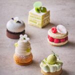 左奥から時計回りに「ほうじ茶と麦茶のなめらかチョコレートタルト」税込み1,650円、「メロンショートケーキ」税込み1,200円、「ほうじ茶ラズベリーマカロン」税込み1,300円、「メロンとライムメレンゲタルト」税込み1,450円、「赤肉メロンとベルガモットシュークリーム」税込み1,300円