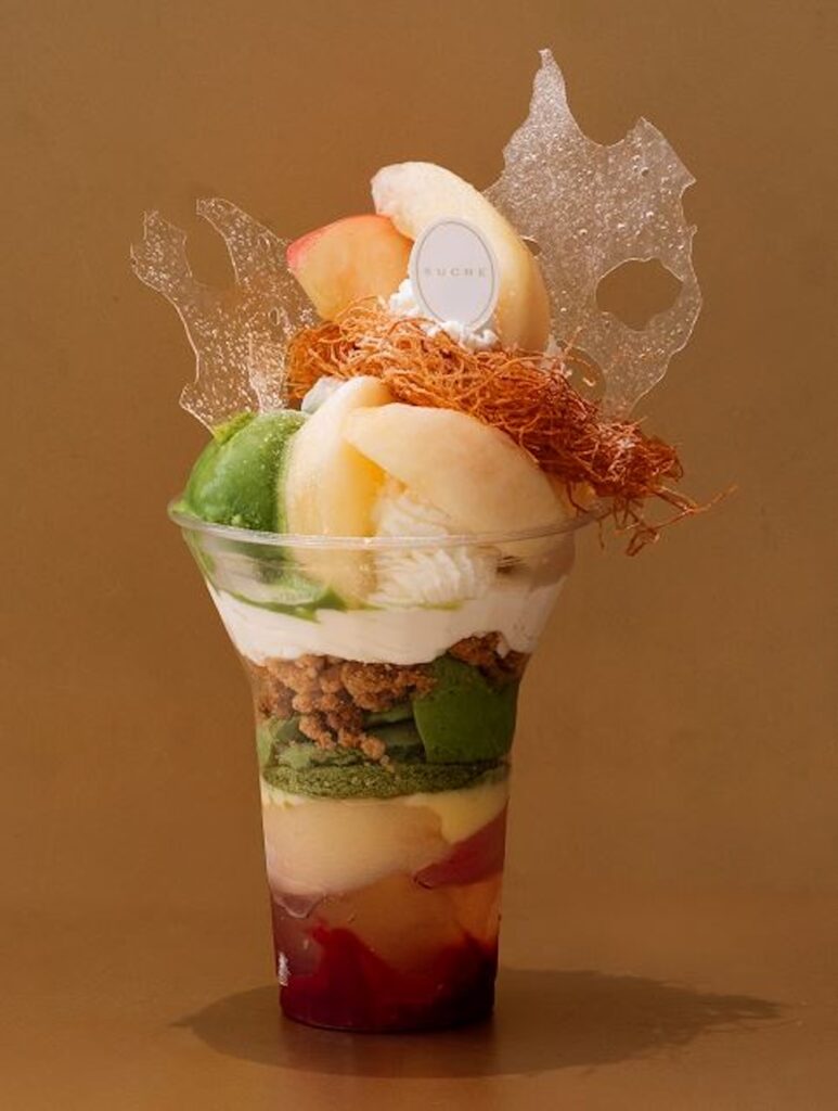 「アンプレシオンガトーシュクル>」の初登場する近鉄本店限定「桃のコンポートと宇治抹茶の翠白（すいはく）パフェ」税込み2,200円（実演）